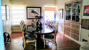 A dining area with a round table, chairs, and a bird painting on the wall.