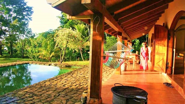 A covered outdoor area with a pool, a hammock, and a metal grill. - Jungle Retreat a House on the beach in the middle of the jungle (Rincon)