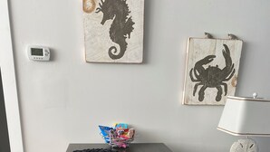 Une table à manger avec deux sets de table, un bol de collations et un thermostat fixé au mur.