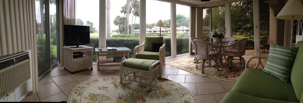 Relax in the living area with a comfortable seating arrangement, TV, and garden view.