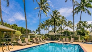 A swimming pool with lounge chairs and palm trees in the background. - Newly Remodeled Ocean View Condo, 2 bedroom, 2 bath, No stairs!  (Princeville)