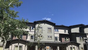 A multi-story residential building with a stone facade, multiple windows, and a central entrance. - Lovely, 3 Bdr, 2 Ba Walk To Eagle Chair, On Sierra Star Golf Course! (Mammoth Lakes)