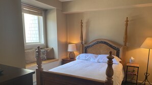 A neatly made bed with a wooden headboard and footboard, a bedside table with a lamp, and a window with blinds. - Lovely, 3 Bdr, 2 Ba Walk To Eagle Chair, On Sierra Star Golf Course! (Mammoth Lakes)