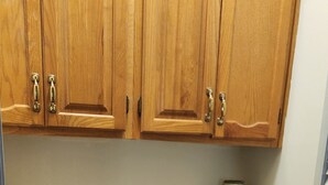 A kitchen with wooden cabinets, a stainless steel sink, and a decorative skull on the countertop. - 1-Level Patio Home Great Location 1 Block from Ocean - NO STEPS! w/ 1-car garage (North Myrtle Beach)