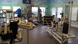 A gym with treadmills, weight machines, and a television screen. - Bahama Bay Resort Unit 28703 - 3BR 2BA Ground Floor Condo - Great Value (Davenport)
