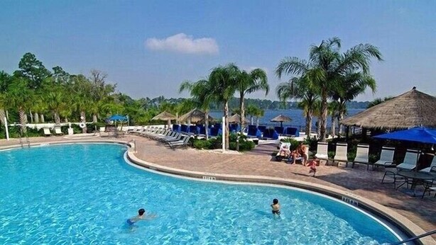 A pool area with clear blue water, lounge chairs, and umbrellas. - Bahama Bay Resort Unit 28703 - 3BR 2BA Ground Floor Condo - Great Value (Davenport)