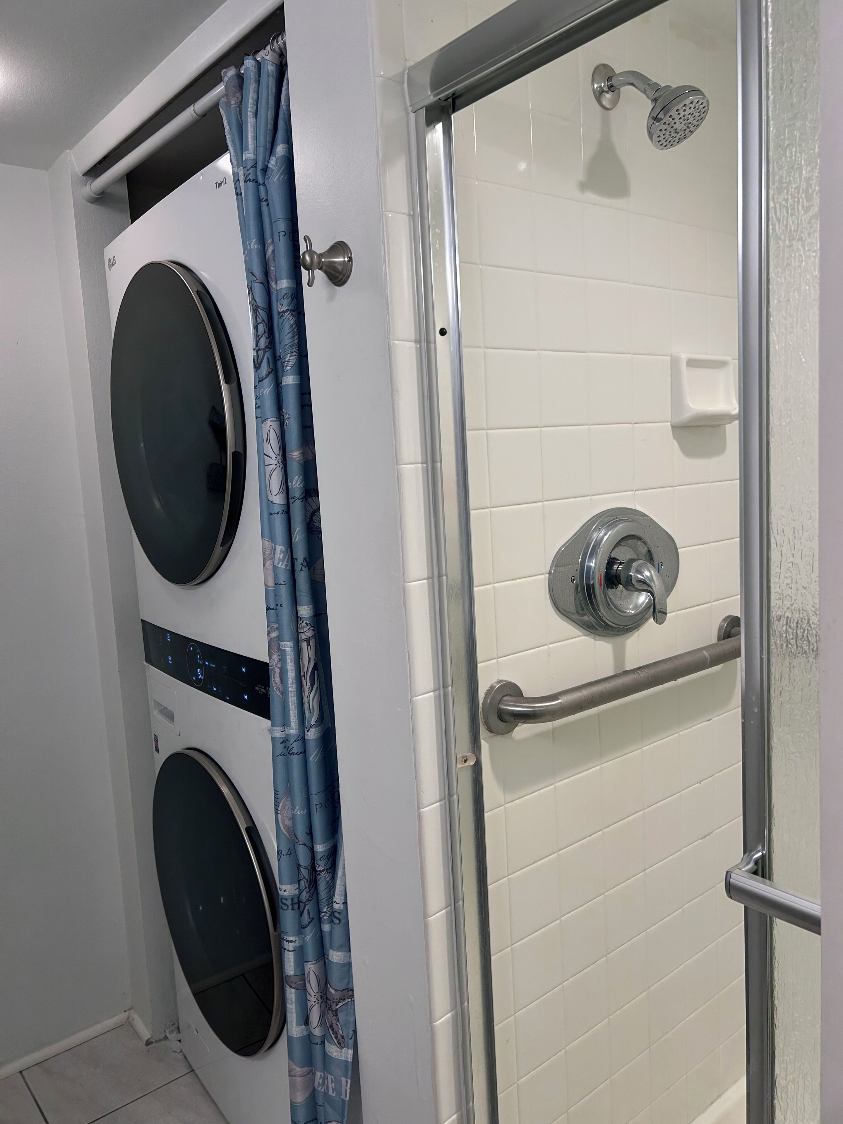 Baño con ducha, inodoro y lavadora.