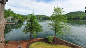 Une propriété paisible située au bord d’un lac, avec un quai, une petite maison et une pelouse bien entretenue.
