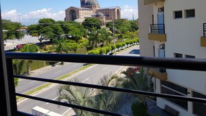 A view of a cityscape with a prominent church with a dome and clock tower, surrounded by greenery and modern buildings. - Hotel Cathedral (Aparecida)