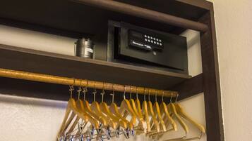 A shelf with a security device and a wooden hanger rack with hangers.