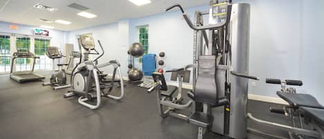A gym with treadmills, elliptical machines, and free weights.