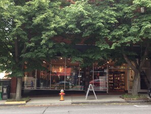 A storefront with large windows, a fire hydrant, and a sidewalk.
