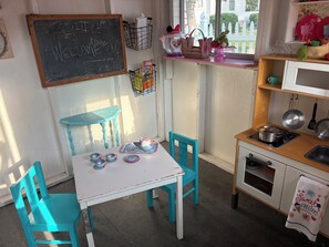 Una cucina con una lavagna, un tavolo con sedie, un forno a microonde e un lavello.