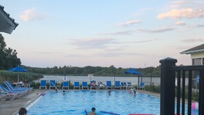 Une piscine à l’eau bleue, entourée de chaises longues et de parasols.