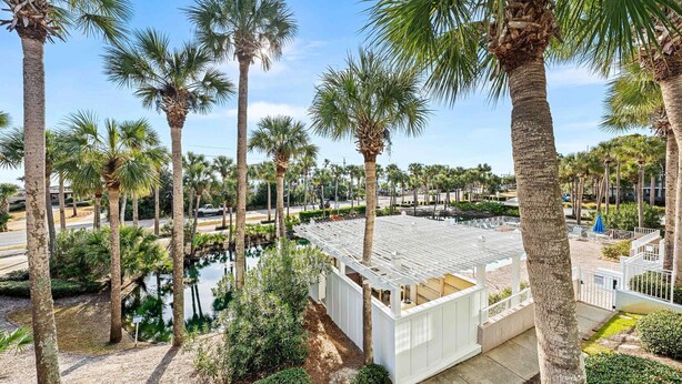 Ein Resort mit Palmen, einem Pool und einem weißen Gebäude mit überdachter Terrasse.