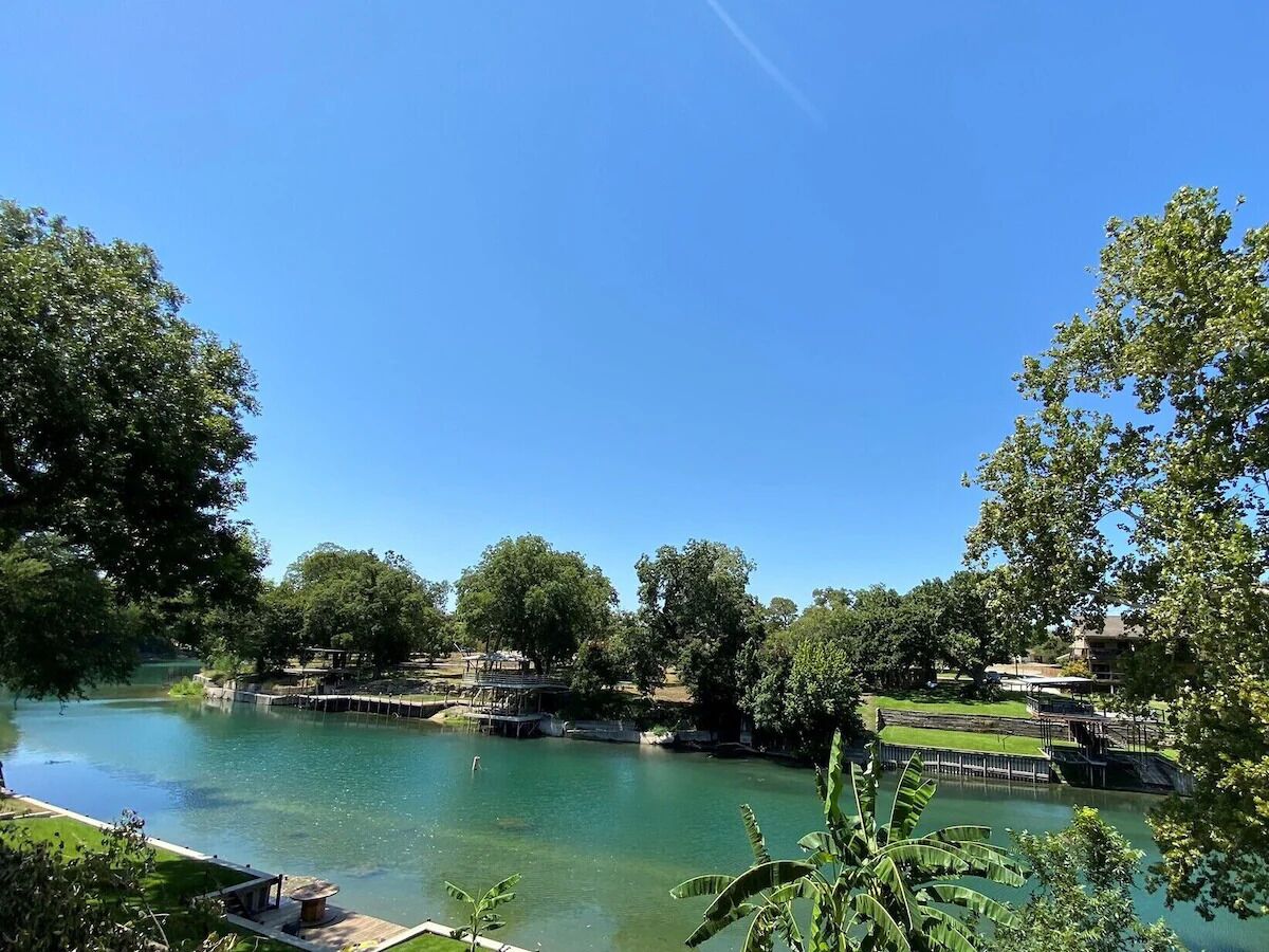 Un parc paisible au bord de la rivière, avec des sentiers pédestres, un petit quai pour bateaux et une végétation luxuriante.