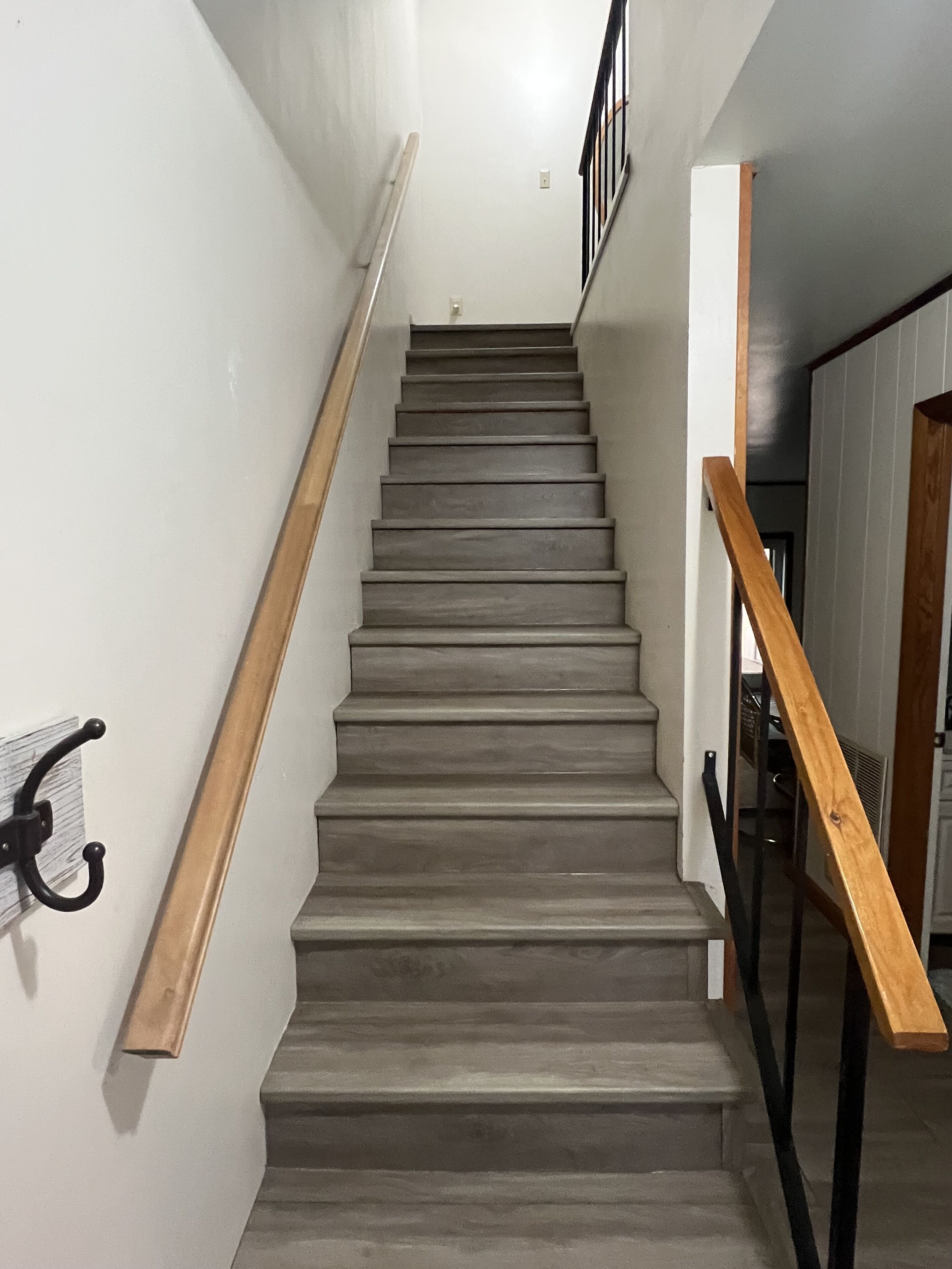 A staircase with wooden handrails and a metal banister.