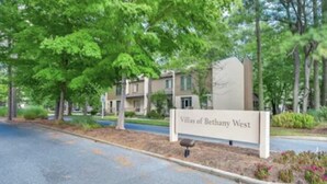 Skilt for Villas of Bethany West, der viser et boligområde med belagt vej og grøn bevoksning.