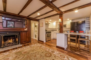 Living room has gas fireplace, 44" TV & large dining/work table with chairs.