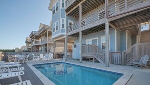 A pool area with lounge chairs and a wooden deck. - 5543-C-Dreams - Nags Head Ocean View Home | Private Pool (Nags Head)
