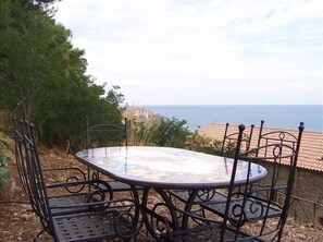 Enjoy meals al fresco at this outdoor dining area with a sea view.