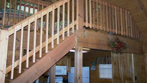 A wooden staircase with a handrail leading to a second-floor area.