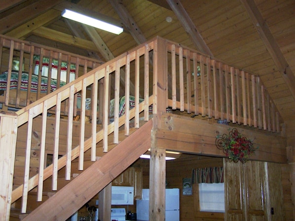 Eine Holztreppe mit Handlauf, die zu einem Bereich im zweiten Stock führt.
