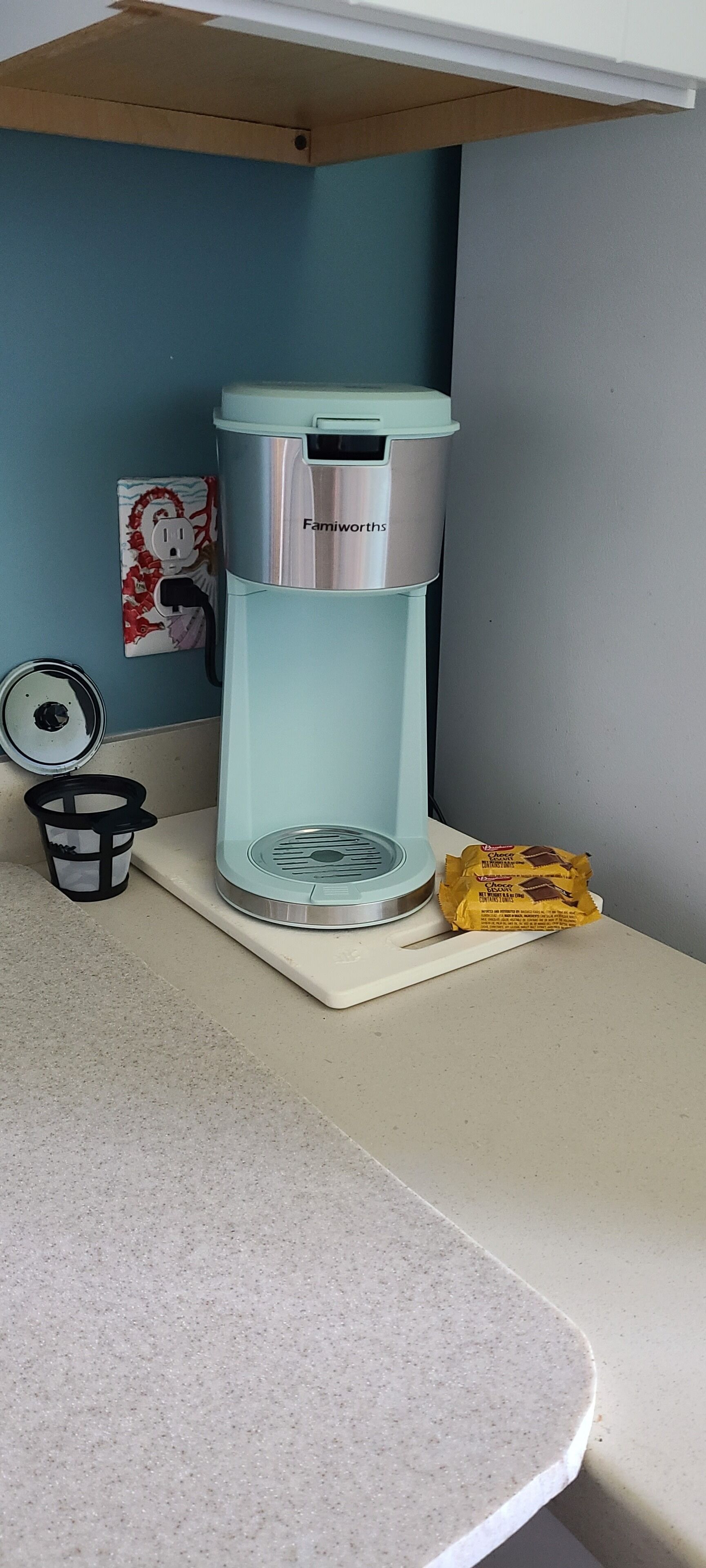 Un comptoir de cuisine avec une machine à café, une poubelle et une barre de chocolat.