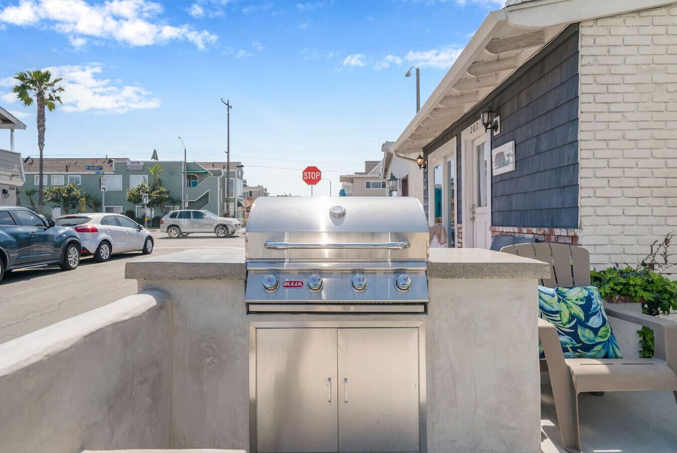 A barbecue grill in a residential area with a stop sign in the background.