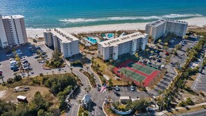 A coastal hotel with multiple buildings, a tennis court, and a pool area. - Dunes of Panama C302 — Sept 1-12 SPECIAL — with Deluxe Free BEACH CHAIR Rentals (Panama City)