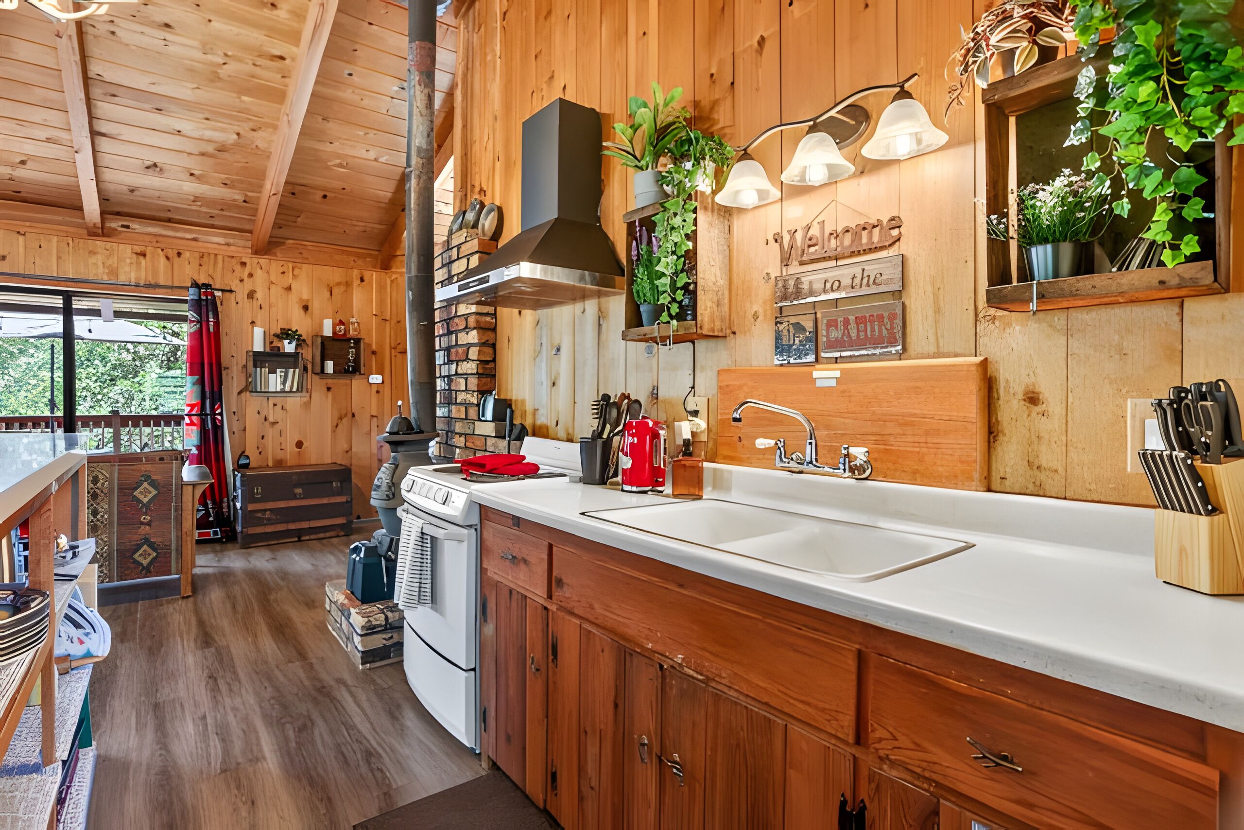 Interior de madera con cocina equipada, que incluye estufa, pileta y alacenas.