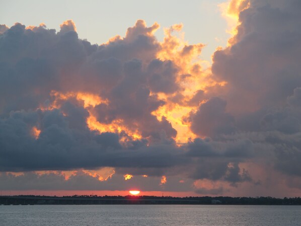 Un coucher de soleil sur une étendue d’eau, avec des nuages.