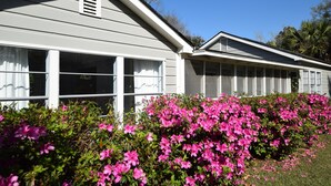 A two-story house with large windows and a covered porch. - Spacious, light-filled mid-century home in Old Town (Bay Saint Louis)