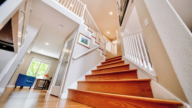 A staircase with wooden steps and white railings, leading to an upper floor. - 8 BR -- 4 Full Baths -- Sleeps 18 - Groups OK - 20 min to Denver or Boulder HUGE (Westminster)