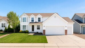 A two-story house with a front garage, a well-maintained lawn, and a clear sky. - 8 BR -- 4 Full Baths -- Sleeps 18 - Groups OK - 20 min to Denver or Boulder HUGE (Westminster)