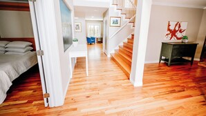 A spacious room with hardwood flooring, a bed, a staircase, and a living area with a blue chair. - 8 BR -- 4 Full Baths -- Sleeps 18 - Groups OK - 20 min to Denver or Boulder HUGE (Westminster)