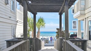 Une passerelle en bois mène à une plage d’où l’on a une vue dégagée sur l’océan.