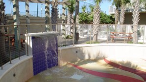 Una fuente con un muro de azulejos azules y una piscina con un diseño colorido.