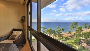 Un balcone con vista sull'oceano e palme.