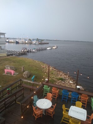 A deck with outdoor seating, a view of the water, and docked boats. - Visit 'Derondo Delight' Beach House - Just Steps from the Gulf (Panama City Beach)