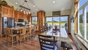 Una cocina amplia con armarios de madera, electrodomésticos de acero inoxidable y un comedor grande con sillas.
