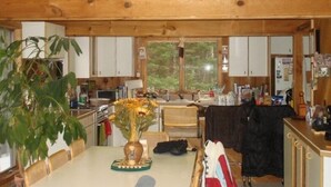 A rustic cabin interior with a dining area, kitchen, and large window. - 1-2 Family Perfection:  Location + Views + Ammenities = Value (West Dover)