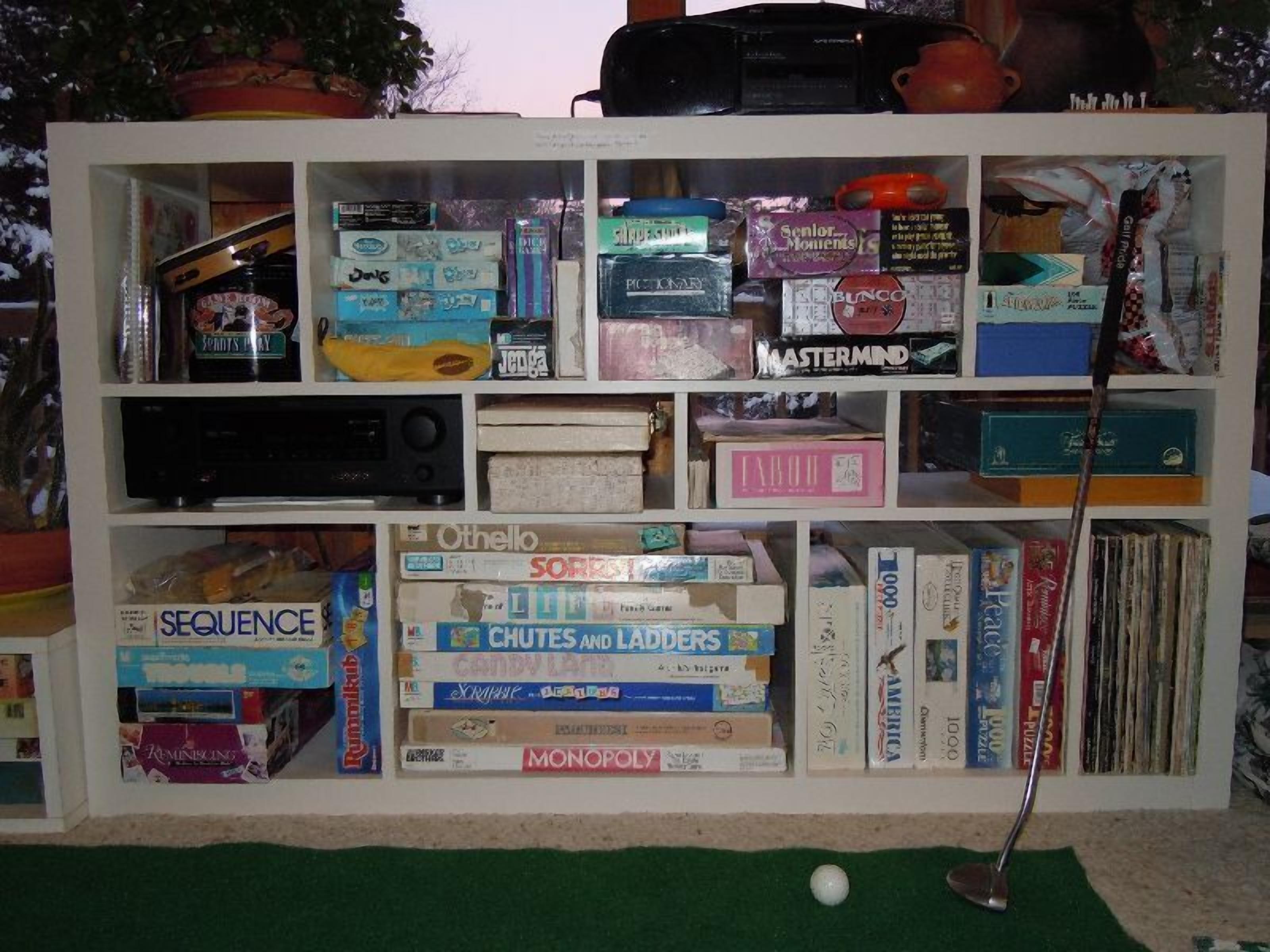 Une bibliothèque remplie de divers jeux de société et de livres.