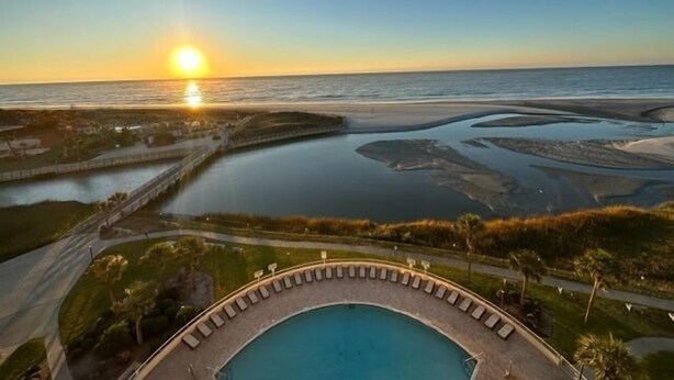 Une piscine offrant une vue sur le coucher de soleil sur l’océan.