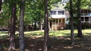A two-story house with a covered porch and a fenced yard.
