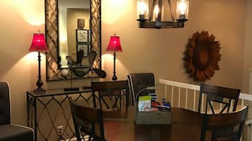 A dining area with a round table, chairs, and two lamps.