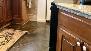 A kitchen with wooden cabinets, a refrigerator, a coffee maker, and a kettle.