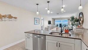 A modern kitchen with a central island, stainless steel appliances, and pendant lighting.