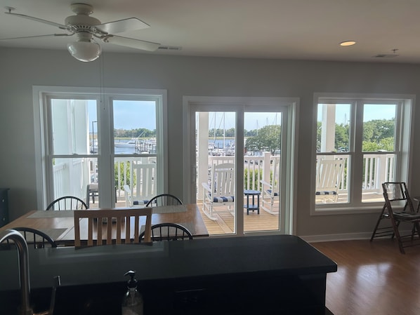 A kitchen with a large island, a ceiling fan, and a view of a marina through large windows.