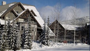A lodge with a large, snow-covered roof and wooden exterior.